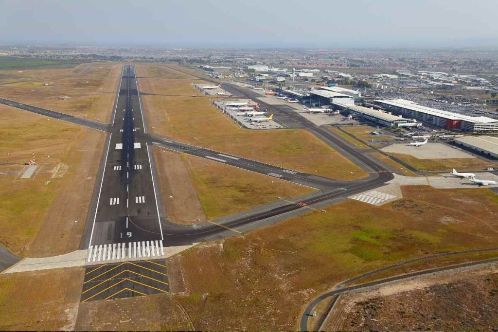 flight disruption UK – Passengers waiting at airport terminal after mass flight cancellations
